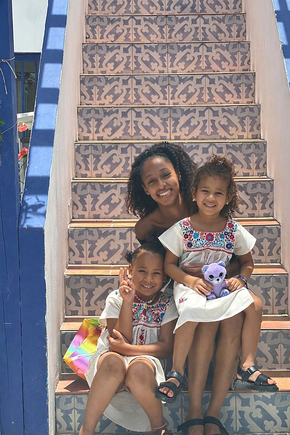 Three sisters on a painted staircase in Puerto Rico